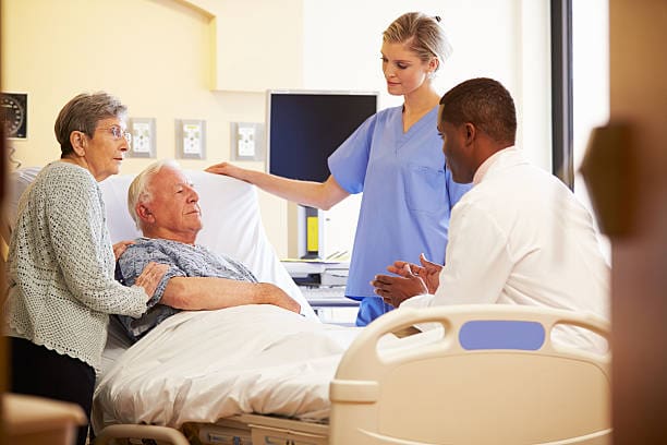 Medical Team Meeting With Senior Couple In Brightly Lit Hospital Room Getty Images